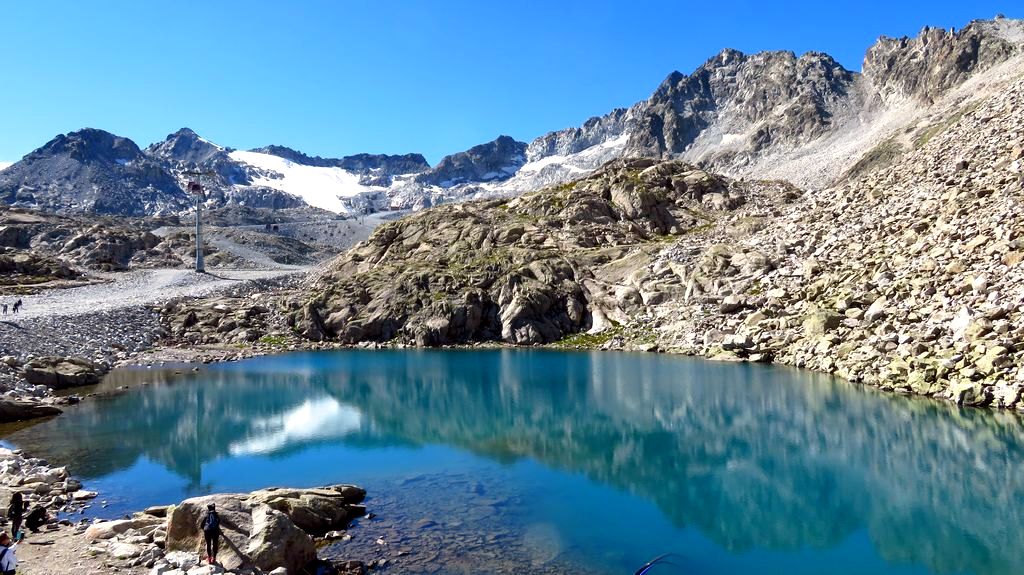 Trekking w Alpach grupa Adamello Presanella. Widok na Cima Presena i lodowiec Presena z nad Lago Monticello